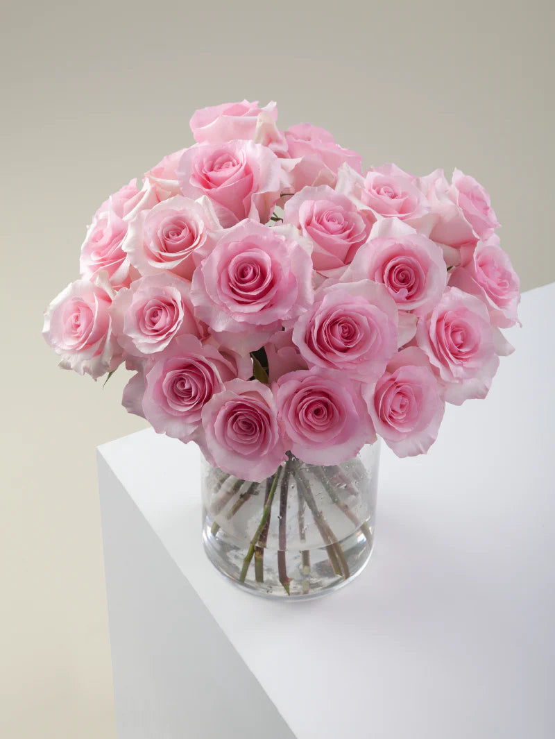 Bouquet of pink roses arranged in a glass vase on a light background.
#color_pink